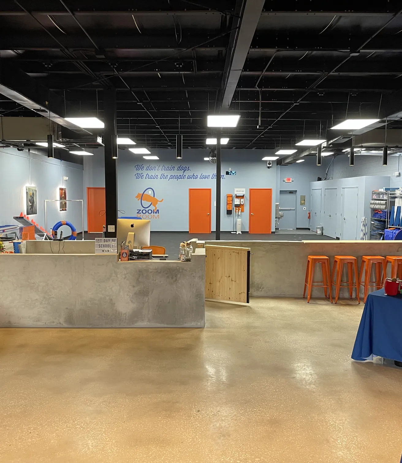 Finished reception counter and retail displays at Zoom Room Longwood, with a polished concrete floor
